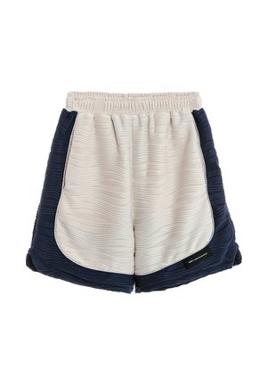 Pantalones cortos de tela texturizada en beige claro y azul marino con cintura elástica, dobladillo curvado y pequeña etiqueta negra en la parte delantera derecha.