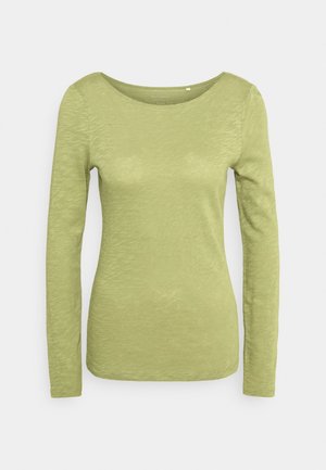 Lysegrøn kvindes langærmet top med rund halsudskæring og tekstureret stof, vist på en ensartet lys baggrund.