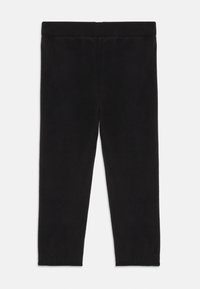 Schwarze Leggings aus weichem, dehnbarem Material. Sie verfügen über einen glatten Bund und ein figurbetontes Design, das bis zur Knöchelhöhe reicht.