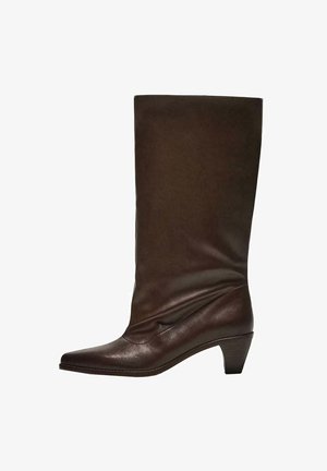 Bota din piele maro închis, până la jumătatea gambei, cu toc joas pe fir, vârf ascuțit și o tulpină ușor lăsată, pe un fundal alb.