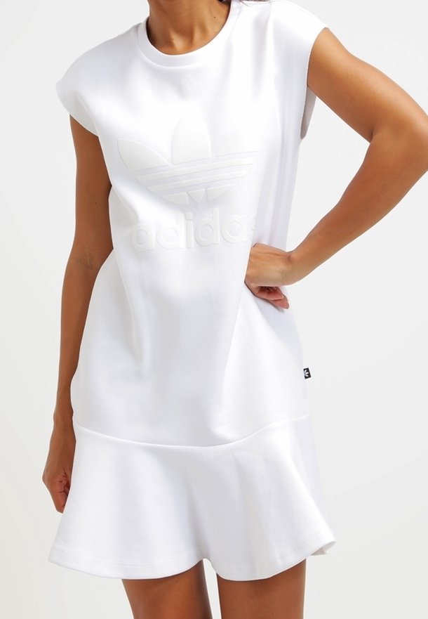 Vit kortärmad klänning med en utsvängd nederkant, prydd med en präglad Adidas-logotyp och en slät, mjuk tygkonstruktion.
