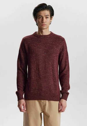 Burgunderfarbener Strickpullover mit Rundhalsausschnitt, gerippten Bündchen und Saum. Hat eine strukturierte Oberfläche mit subtilen Farbtupfern.