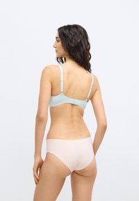 Ανοιχτό μπλε, υφασμάτινο σουτιέν με ρυθμιζόμενους ιμάντες, συνδυασμένο με απλό, μπεζ εσώρουχο. Απλός, μινιμαλιστικός σχεδιασμός, χωρίς ορατά σχέδια.