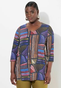 Bunt gemusterte Bluse mit Dreiviertelärmeln, die ein geometrisches Muster in Lila, Rot, Orange und Blau auf schwarzem Hintergrund zeigt.