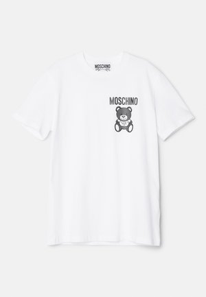 Camiseta de algodón blanca con un gráfico impreso de un oso de peluche negro y el texto "Moschino" en el lado izquierdo del pecho. Diseño de mangas cortas y cuello redondo.