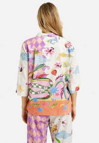 Colorful, patterned pajama set featuring short sleeves, a mix of textures, and various illustrations including animals and abstract designs.