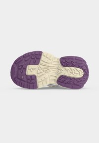 Semelle d’une basket avec des motifs d’empreinte profonds en caoutchouc blanc et violet pour l’adhérence et la durabilité.
