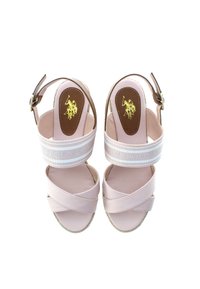 Růžové espadrilové sandály s křížovými popruhy, které mají bílý značkový pásek a hnědou vnitřní stélku se zlatým logem. Nastavitelný kotníkový pásek.