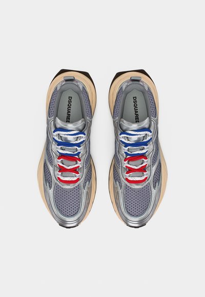 Αθλητικά παπούτσια από ασημένιο δίχτυ με μπεζ σόλες και κορδόνια σε κόκκινο, λευκό και μπλε, με την ετικέτα DSQUARED, ορατά από πάνω.