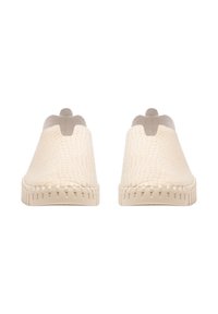 Zapatos tipo slip-on beige texturizados con un patrón de reptil, punta redondeada y diseño minimalista. Presenta una suela cosida y una pequeña pestaña en la parte trasera.