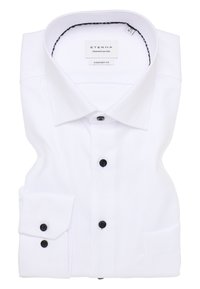 Witte tekstuurlange mouw shirt met zwarte knopen, keurig gevouwen, gelabeld met "ETERNA Comfort Fit" binnen de kraag.