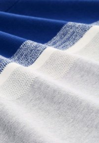 Gestreifter Stoff in Blau-, Hellblau- und Weißtönen. Weiche Textur mit unterschiedlichen Strickmustern. Glatte und leicht strukturierte Bereiche.