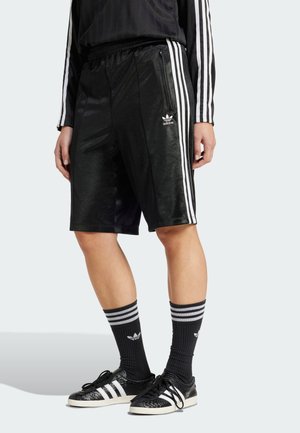 Pantaloni scurți sport negri cu trei dungi albe pe laterale, având un luciu subtil și un logo Adidas pe marginea stângă. Modelul este asortat cu șosete în dungi.
