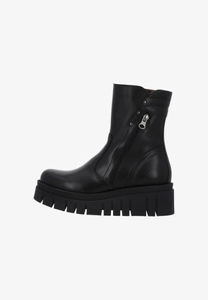 Bottines en cuir noir avec semelle lug épaisse, fermeture éclair latérale et détail de col rembourré.