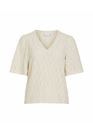 Blouse crème à manches courtes avec col en V et motif hexagonal texturé, présentant de légères épaules bouffantes.