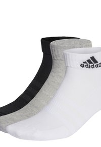 Tres pares de calcetines tobilleros en negro, gris y blanco. Los calcetines tienen puños acanalados y presentan el logo de Adidas en negro en el par blanco.