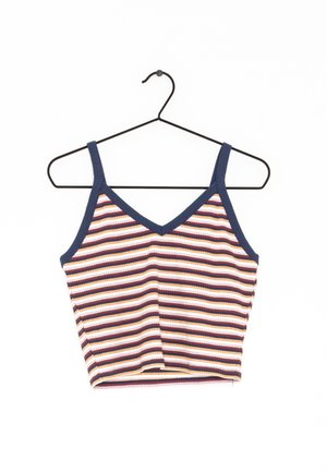 Prążkowany krótki top na ramiączkach z granatową lamówką na czarnym wieszaku na białym tle.