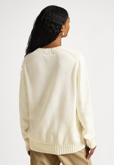 Πλεκτό πουλόβερ σε κρεμ απόχρωση με άνετη εφαρμογή, ριμπ μανσέτες και τελείωμα. Διαθέτει υφασμένο μοτίβο και λαιμόκοψη.