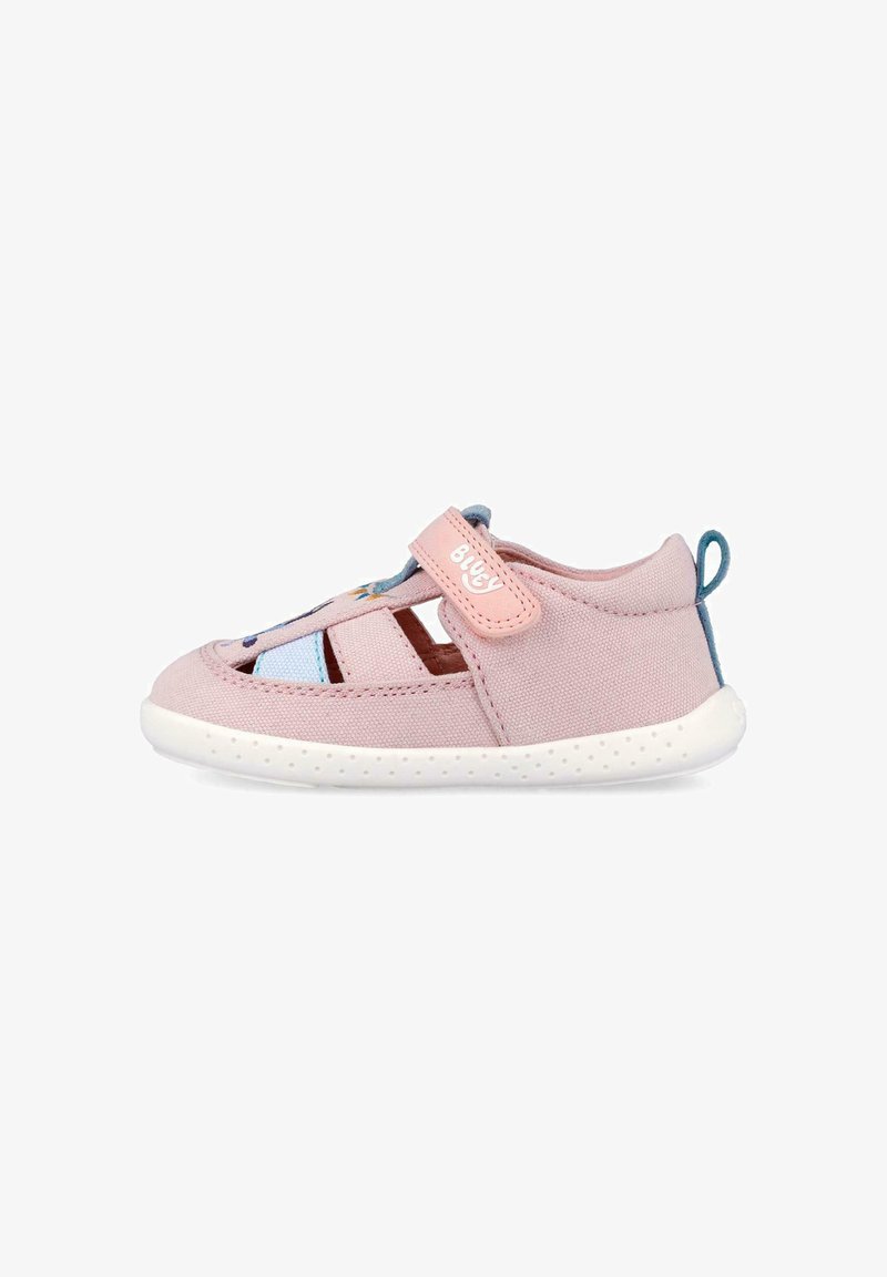 Sandalia rosa para niño pequeño con aberturas transpirables, correa de velcro con la etiqueta "Bugy" y suela blanca flexible con lazo azul en el talón.