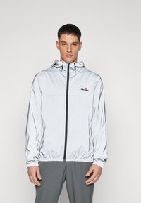 Silberne, leichte Zip-Jacke mit Kapuze. Verfügt über elastische Bündchen und Saum, Logo-Detail auf der Brust und eine glatte, glänzende Textur.
