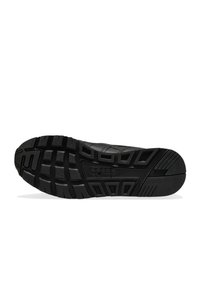 Sole di scarpa da ginnastica in gomma nera con superficie testurizzata e pattern vari per migliorare la trazione, logo impresso e design robusto.