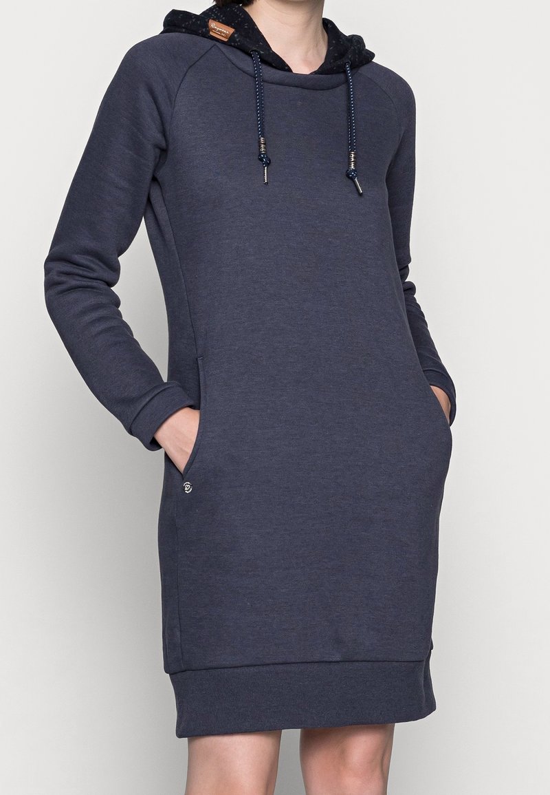 Dunkelblaues Sweatkleid mit Kapuze, ausgestattet mit gerippten Ärmelbündchen und Saum, vorderen Taschen und kontrastierenden Kordeln. Weiches Material mit glatter Textur.