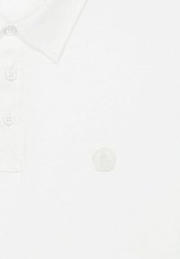 Witte poloshirt met een klassieke kraag, drie knoopsluitingen en een klein, reliëflogo op de borst. Zachte stoftextuur.