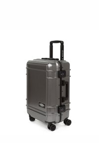 Hard-shell suitcase in metallic gray, featuring a telescopic handle, four wheels, combination lock, and textured surface for durability.