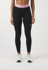 Crne tajice sa širokim ružičastim pojasom označenim "PRO NIKE." Sadrže mali bijeli Nike logo na lijevoj nozi. Glatki, rastezljivi materijal.