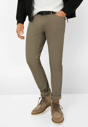 Khaki slim-fit pants with a textured finish, featuring side pockets and rolled cuffs, paired with brown lace-up boots on a white background.