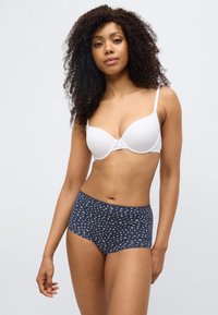 Λευκό επενδυμένο σουτιέν με λεπτομέρεια μπροστινού φιόγκου, συνδυασμένο με σκούρο μπλε, ψηλόμεσο εσώρουχο με μικρό λουλουδάτο σχέδιο σε υφασμάτινη υφή.