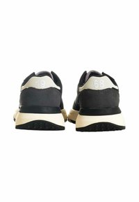 Un paio di sneaker nere e beige viste da dietro, con "19" sul tallone sinistro e "68" sul tallone destro.