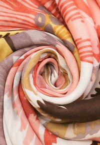 Sciarpa in twill con motivi floreali in tonalità di corallo, marrone e giallo, caratterizzata da una finitura morbida e testurizzata e da un design arrotolato.