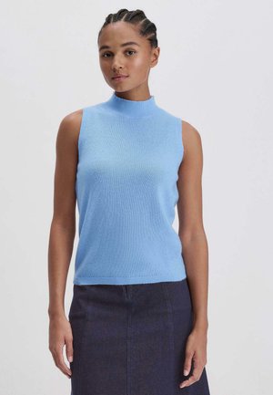 Ärmelloses, hellblaues Strickoberteil mit hohem Kragen, weicher Textur und geripptem Saum, getragen mit einem dunklen Denim-Rock.
