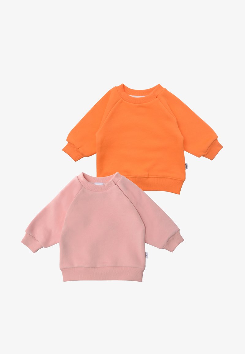 Zwei Sweatshirts: eines in Orange, eines in Pink. Beide haben Raglanärmel, runde Hälse und einen weichen, strukturierten Stoff. Keine Muster oder sichtbare Beschläge.
