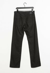 Černé kalhoty s rovnými nohavicemi vyrobené z texturované látky, s páskem, poutky na pásek a dvěma zadními kapsami. Visí na černém plastovém ramínku.