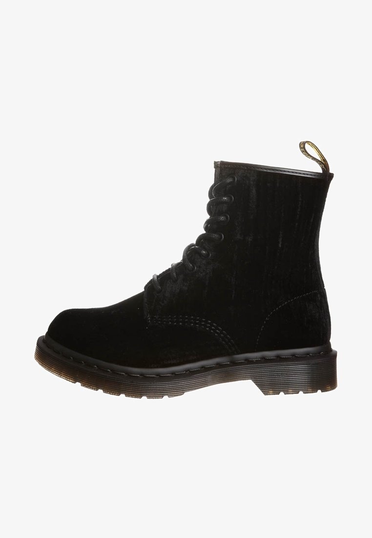 Černé semišové kotníkové boty s kulatou špičkou, prošíváním ve vzoru, gumovou podrážkou a poutkem na patě. Texturovaný povrch dodává hloubku.