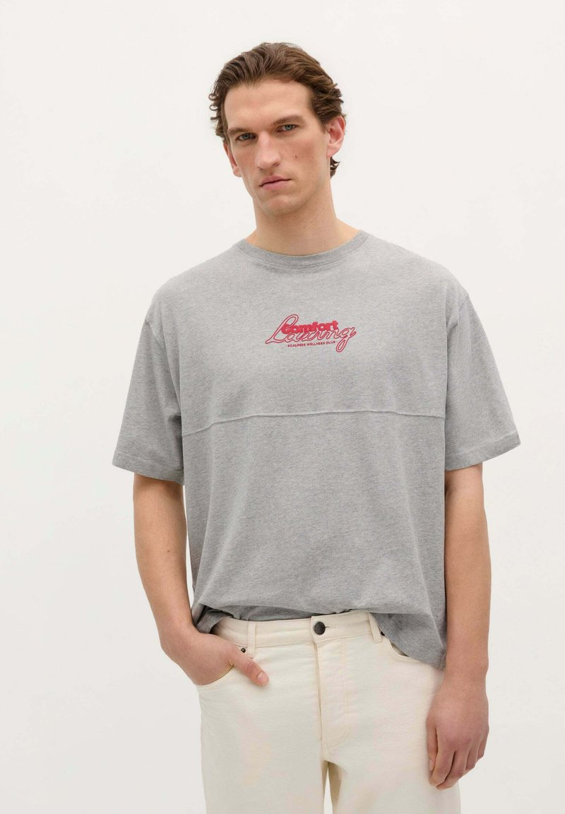Grijs katoenen t-shirt met korte mouwen met een rode grafische tekst "Comfort Loving" over de borst; ontspannen pasvorm, ronde hals.