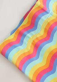 Višebojna tkanina s valovitim prugama u ružičastoj, narančastoj, žutoj, plavoj i zelenoj boji; ima glatku teksturu i vidljive šavove.