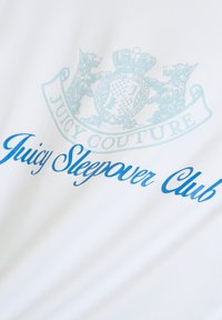 Tissu blanc avec un motif graphique bleu clair. Le texte indique « Juicy Sleepover Club » en écriture cursive fluide, avec un logo au-dessus.