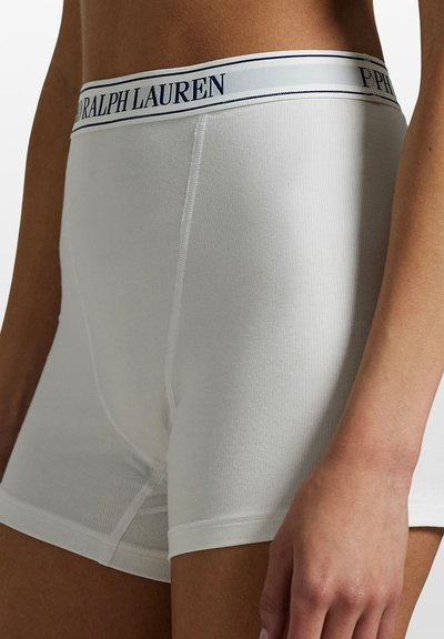 Vita bomullsboxershorts med ribbad struktur och en midjeresår med "Ralph Lauren"-logotyp i mörkblå text.