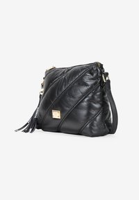 Bolso de mano cruzado de cuero negro con diseño acolchado, herrajes dorados, cierre de cremallera y adorno de borlas desmontable. Forma compacta y estructurada.