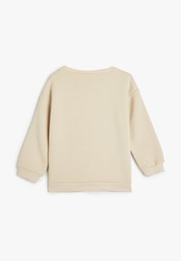 Sudadera color beige claro con una textura suave, hombros caídos, puños acanalados y un cuello redondo. Diseño simple y minimalista sin adornos.