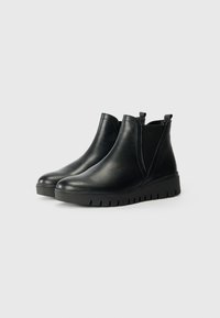 Schwarze Leder-Ankle-Boots mit elastischen Seitenpaneelen, runder Spitze und strukturiertem Gummisohle mit dicker, genoppter Konstruktion.