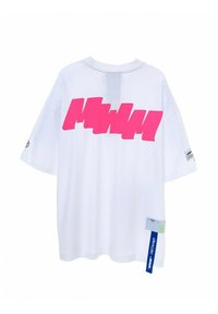 Camiseta corta blanca de gran tamaño con un gran estampado gráfico vibrante en color rosa en la parte posterior, mangas cortas y una etiqueta con acentos en azul y verde.