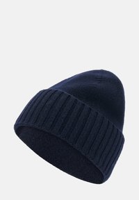 Marinblå stickad mössa med ribbad kant, tillverkad av mjukt och texturerat tyg. Har en rundad topp och en sömlös design.