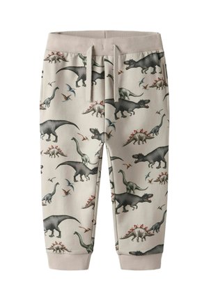 Pantalon de jogging beige pour enfants avec taille élastique et motif de dinosaures comprenant T-Rex, stégosaure, brachiosaure et ptérodactyle.