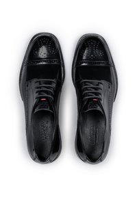 Scarpe eleganti in pelle nera con design liscio e perforato. Presentano punta rotonda, chiusura con lacci e suola in gomma testurizzata.
