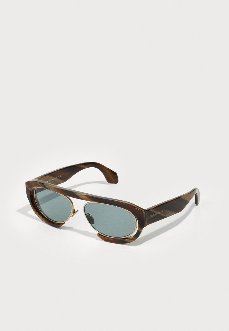 Tortoiseshell ovālas saulesbrilles ar zaļiem stikliem; satur zelta akcentus un vienu eņģi. Strukturētais rāmis nodrošina elegantu izskatu.