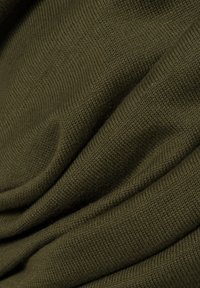 Olivgrüner Stoff mit einem glatten, strukturierten Strickmuster, das sanfte Falten und Drapierungen zeigt, die Elastizität und Weichheit anzeigen.
